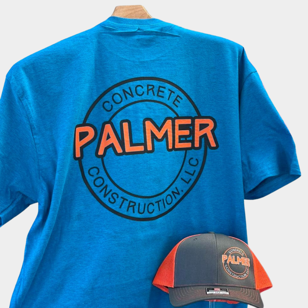 Blue t-shirt with orange and black lettering that says "Palmer CONCRETE CONSTRUCTION LLC" and a grey and orange hat with a Palmer Concrete Construction LLC logo