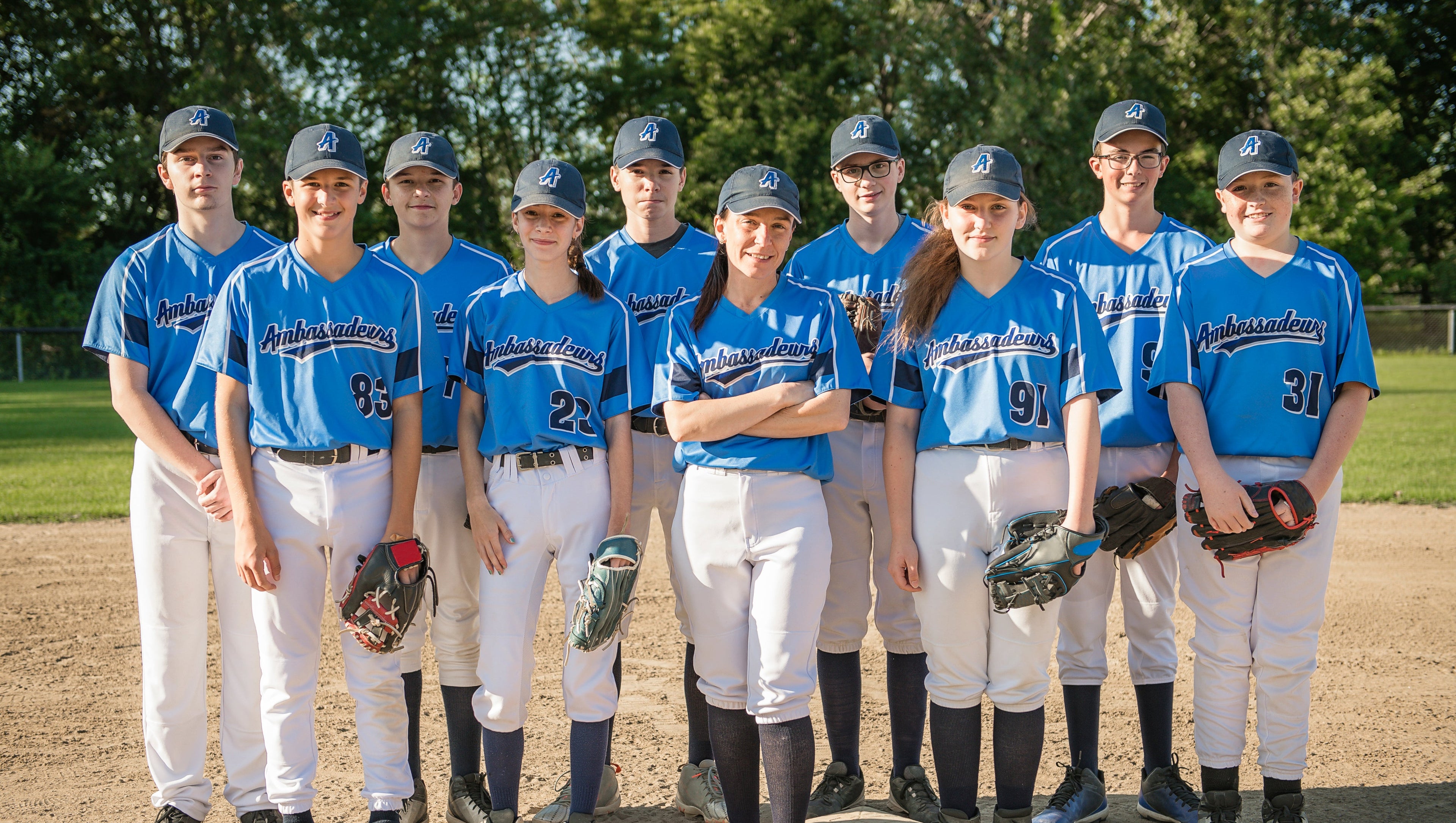 Baseball team posing on a field with blue uniforms and caps.